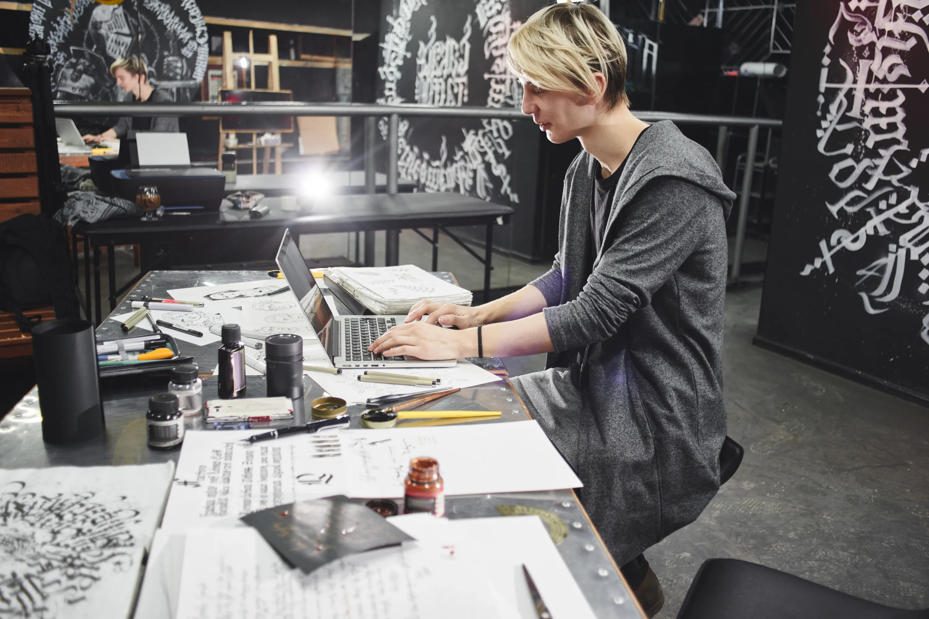 Tätowierer arbeitet am Laptop im Tattoostudio an der Buchhaltung