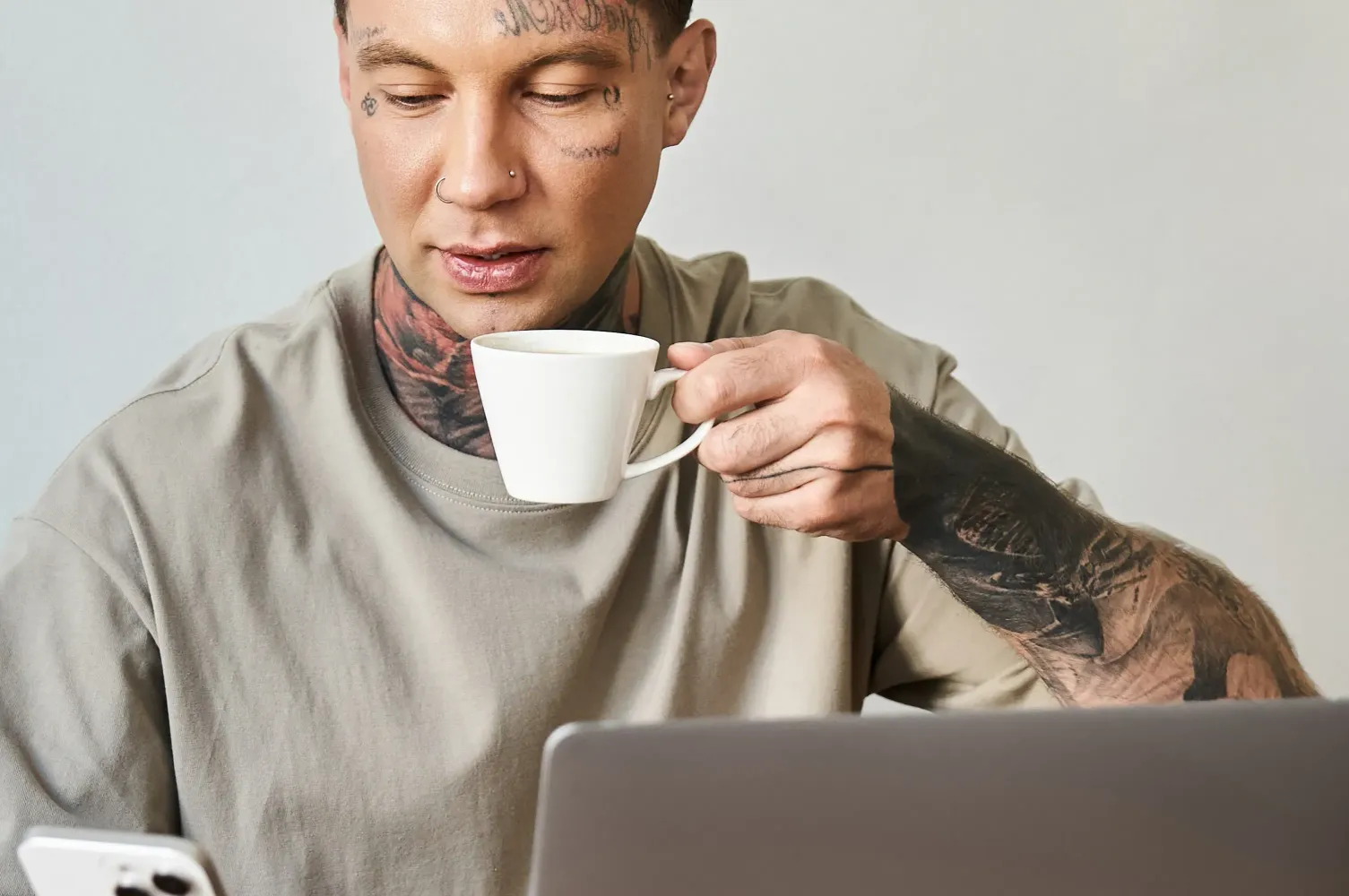 Tätowierer berechnet seinen Stundensatz am Laptop im Tattoostudio